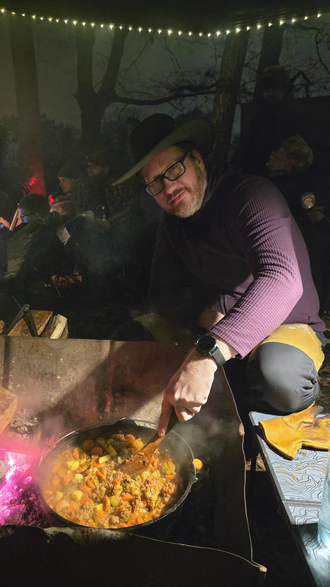 Man cooking a meal on a campfire.
