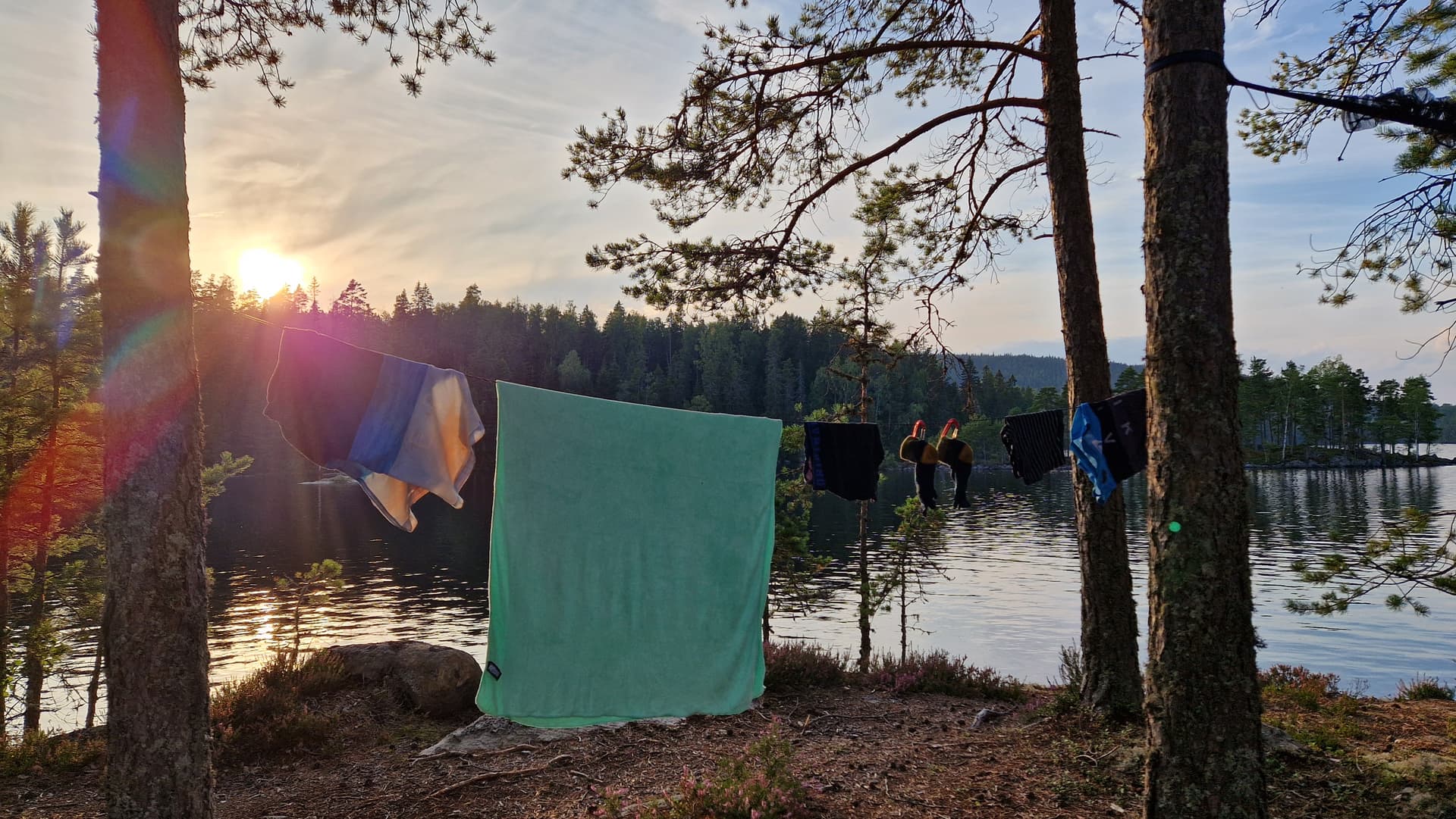 Washed clothes on a line next to a lake.