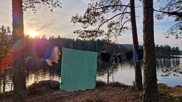 Washed clothes on a line next to a lake.