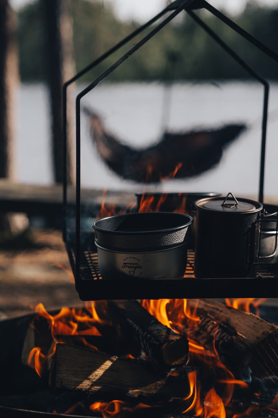 Cooking pots on a campfire with a hammock in the background. Cooking pots on a campfire with a hammock in the background.