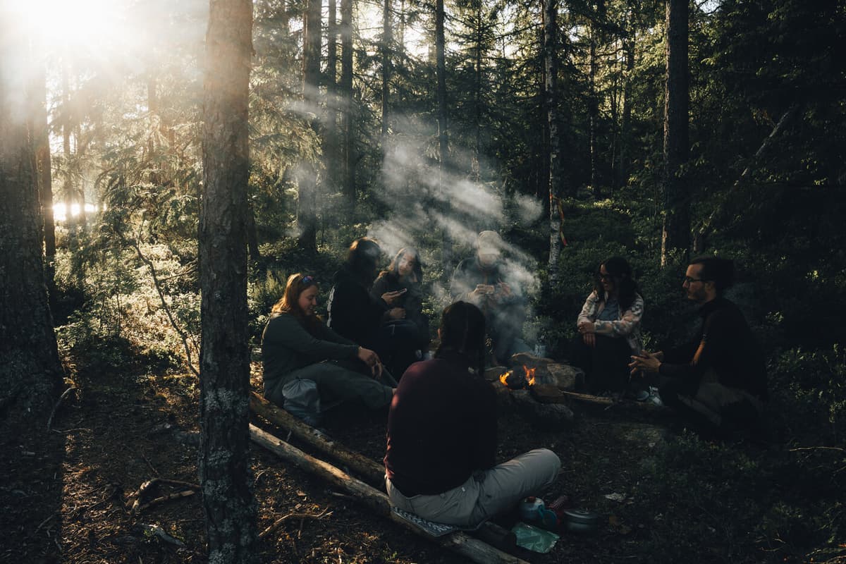 Peoplee sitting around a campfire.