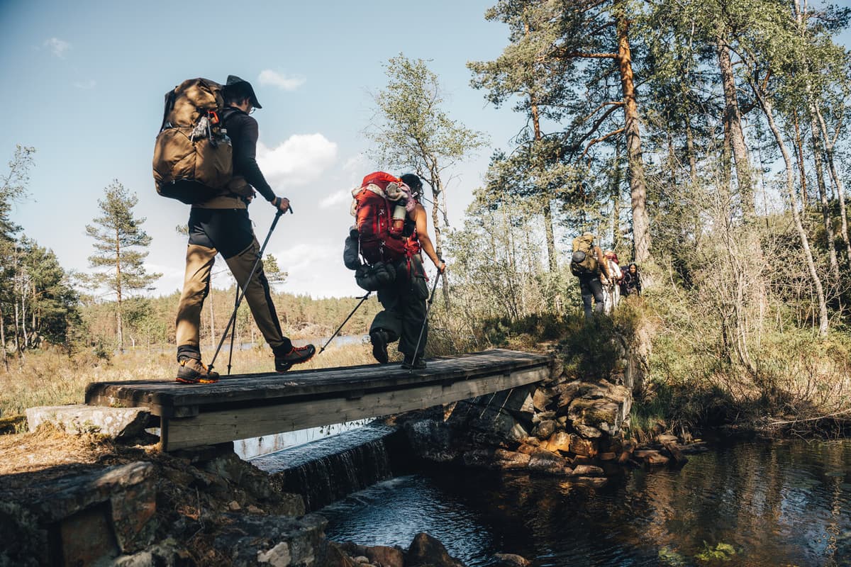 People walking on wooden planks across a river.